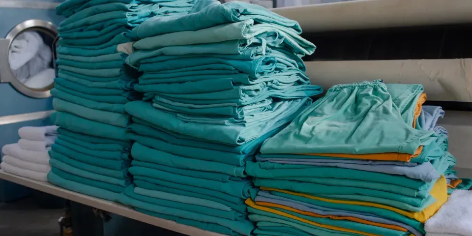 Stack of modern day green scrubs neatly folded in a pile